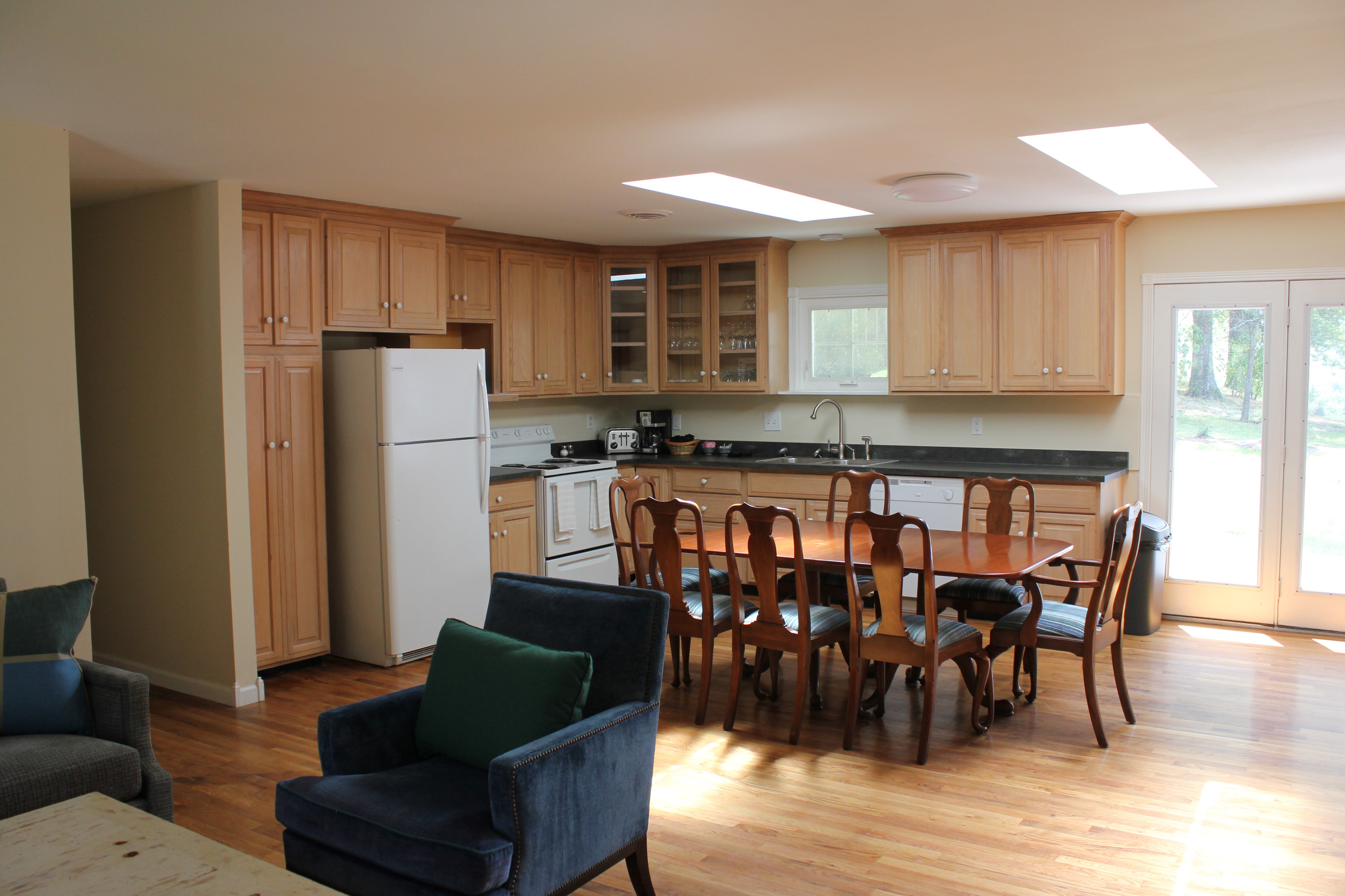 The main living area with a large coffee table and sofa.  The room is open and the full kitchen and dining room table is in the background.