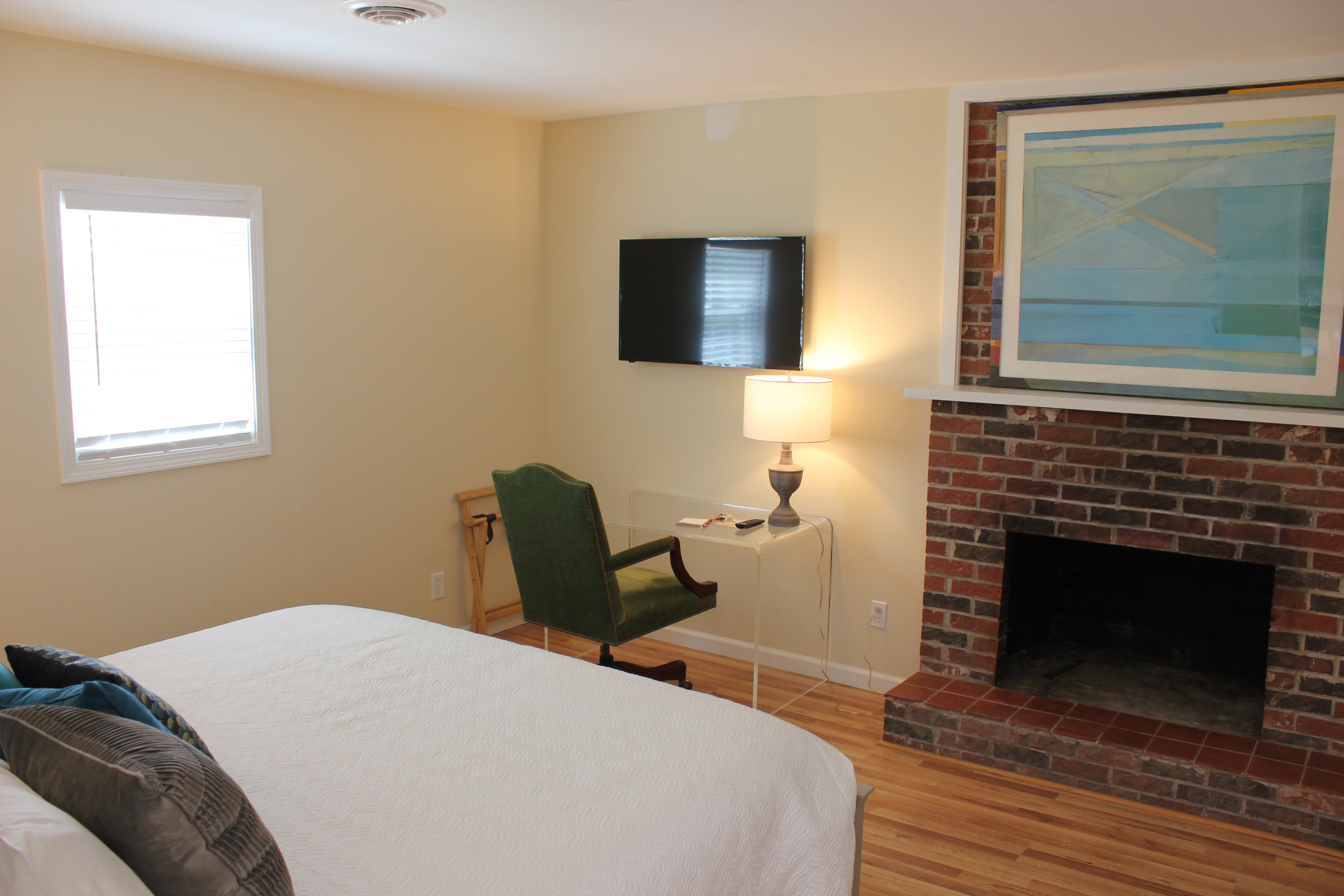 One of three king bedrooms in the unit.  The bed is to the left, a plexiglass desk is center in the photo, and to the right of the desk is an inoperable fireplace.  Above the desk is a television.