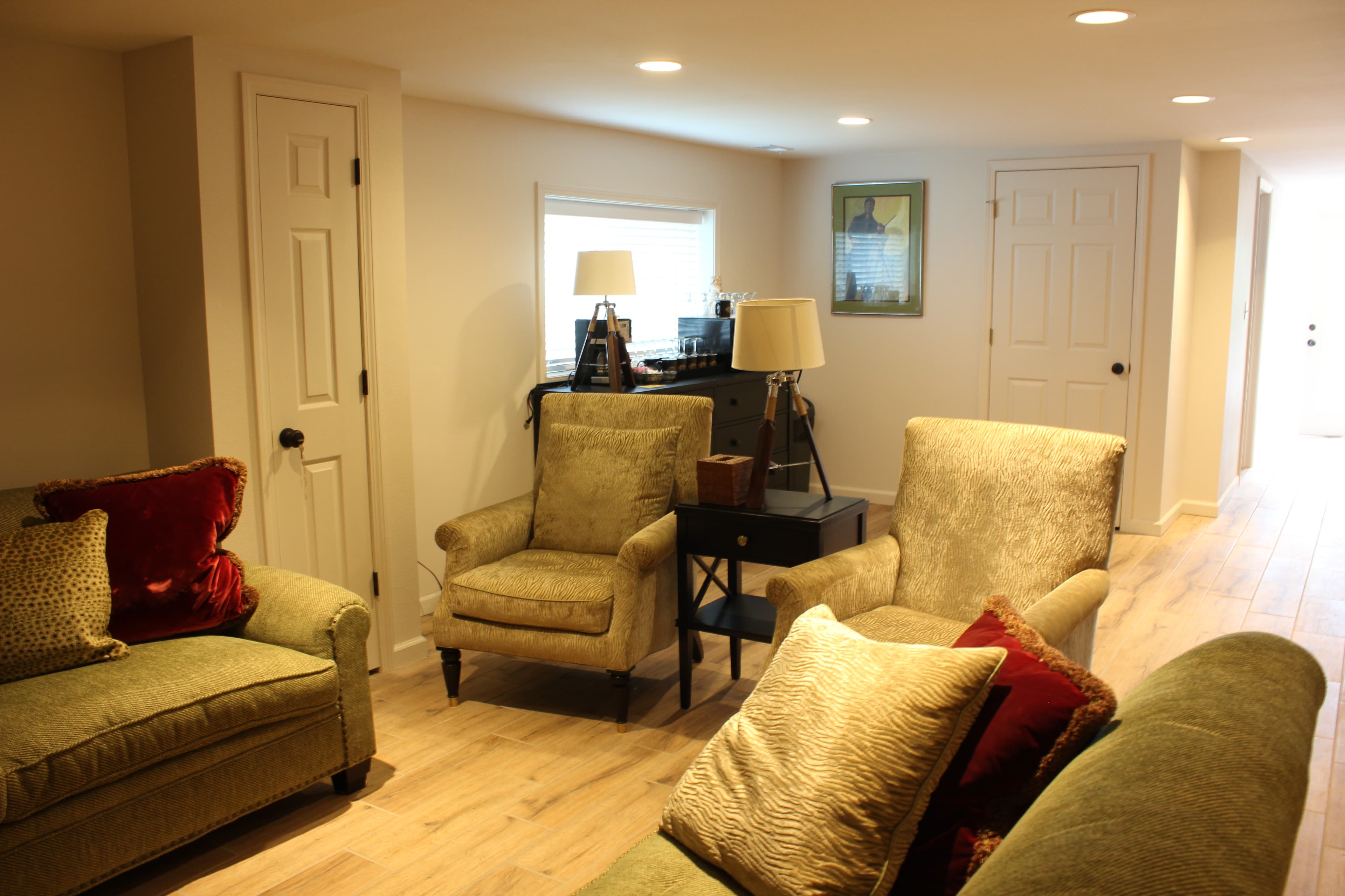 The seating/gathering area of the room.  It has two sofas, a couple chairs and a large TV.  In the very back is a coffee station setup.