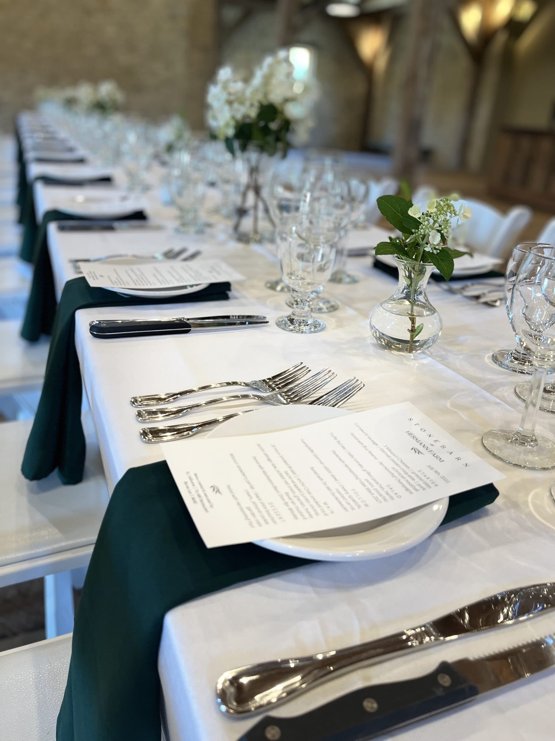 A beautifully set dining table featuring elegant glassware, polished cutlery, and floral centerpieces.