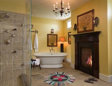 A stylish bathroom featuring a glass shower, freestanding tub, fireplace, and decorative wall art.