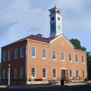 Historic brick building with a clock tower and large windows.
