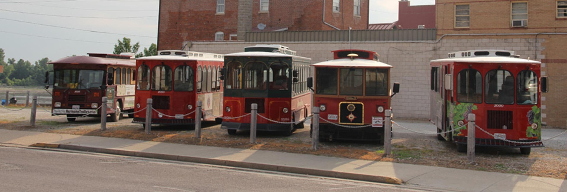A row of colorful trolley cars parked next to a building.
