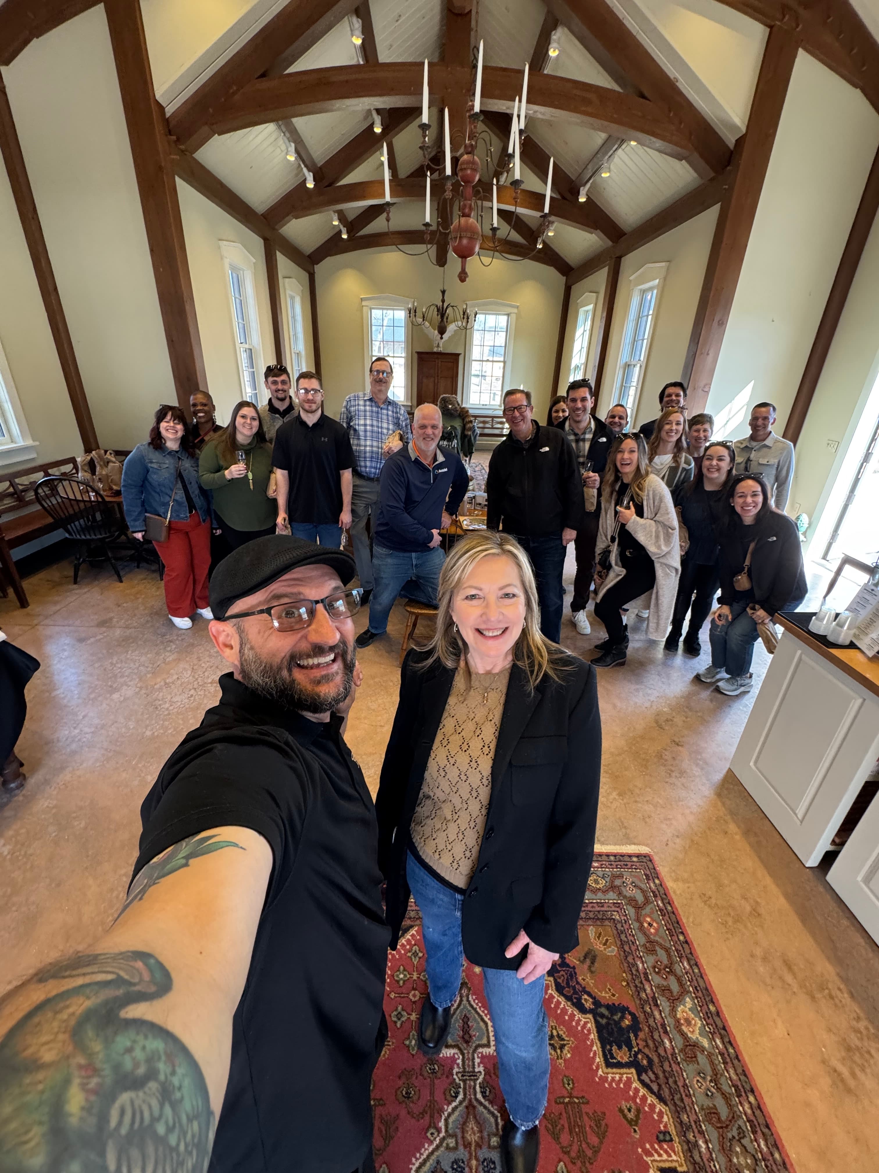 A group of people poses for a selfie in a rustic interior space.
