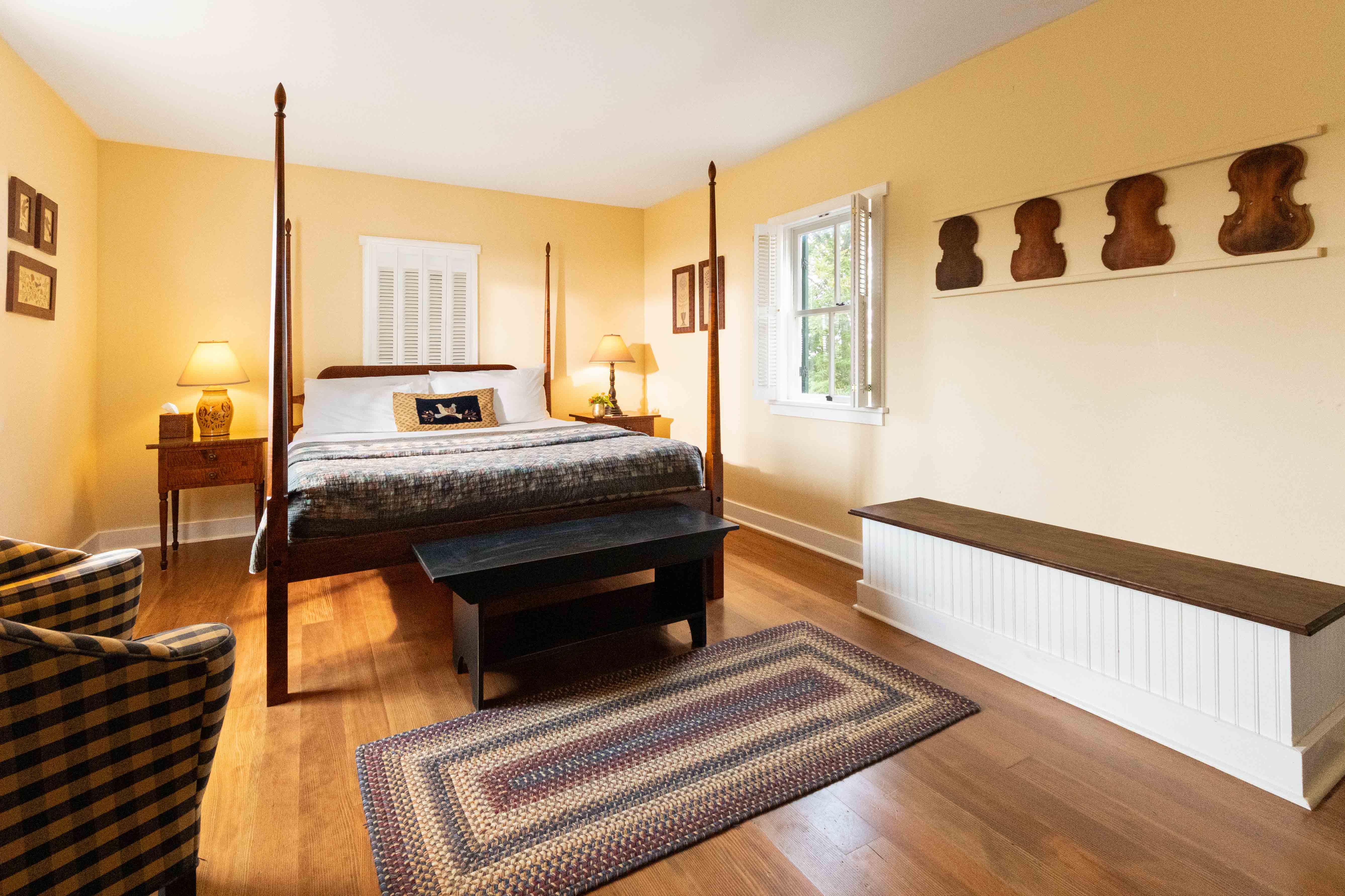 A cozy room featuring a four-poster bed, a checkered chair, and decorative wooden accents.